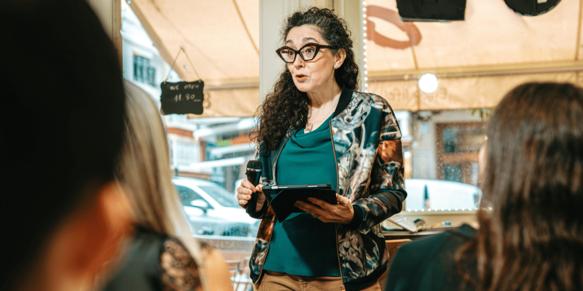 woman public speaker wearing an eyeglasses with an iPad on her hand